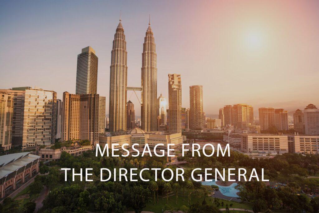 A cityscape at sunset with tall skyscrapers, including the Petronas Towers, and the text MESSAGE FROM THE DIRECTOR GENERAL overlaid in white letters.
