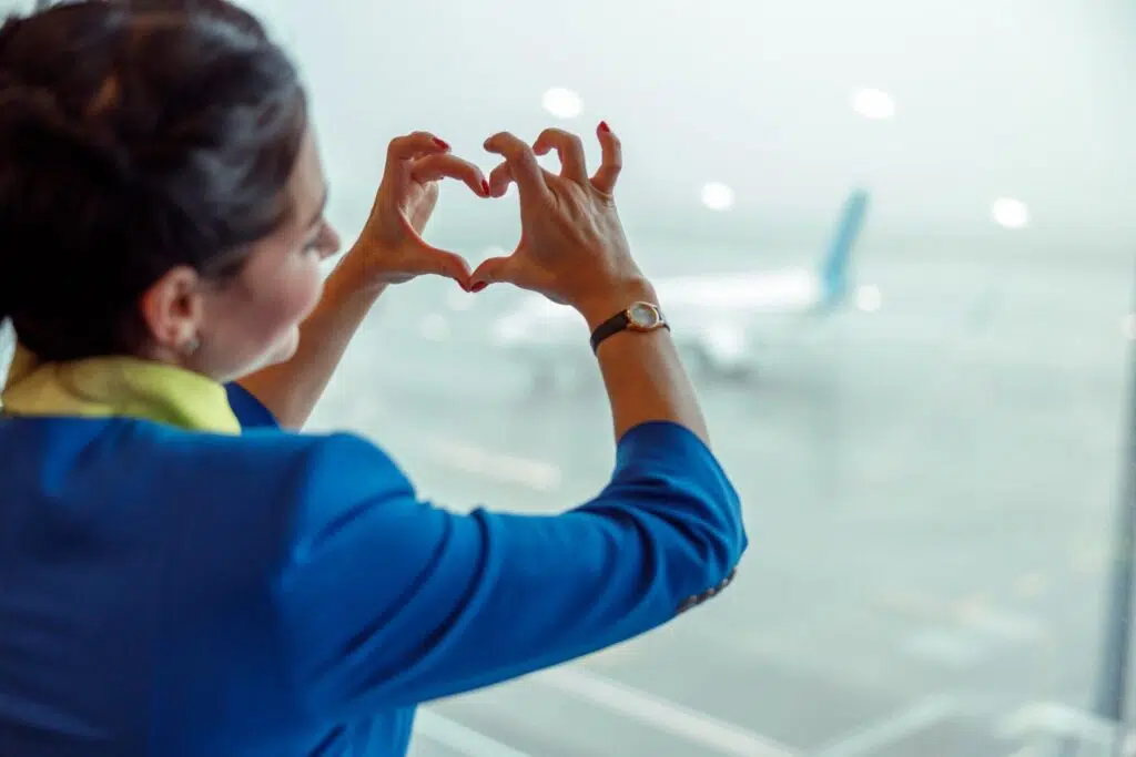 Close,Up,Of,Woman,Stewardess,Making,Heart,Sign,With,Hands